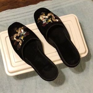 Black slippers with beaded detailing.